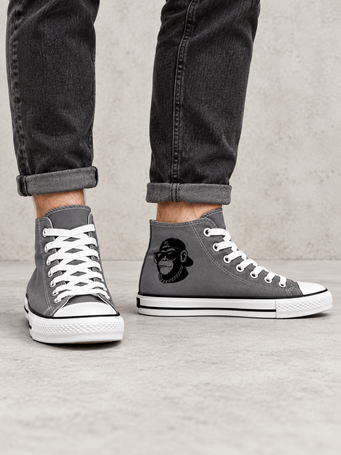 Grey Ape Street OG Chimp high-top trainers worn with charcoal jeans, showing chimp side graphic and white soles.