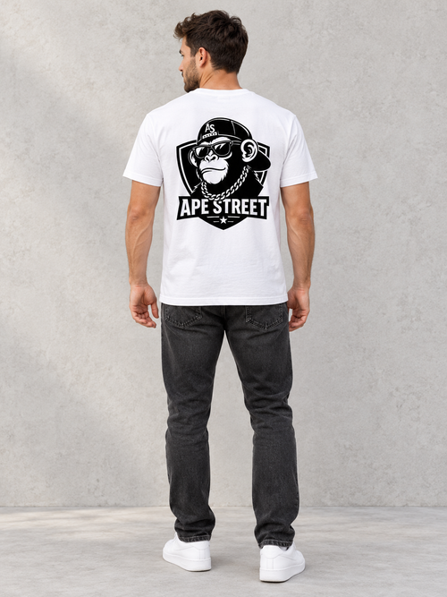 Model wearing Ape Street OG Chimp Back Print Tee, back view showing the back print, against a light concrete backdrop.