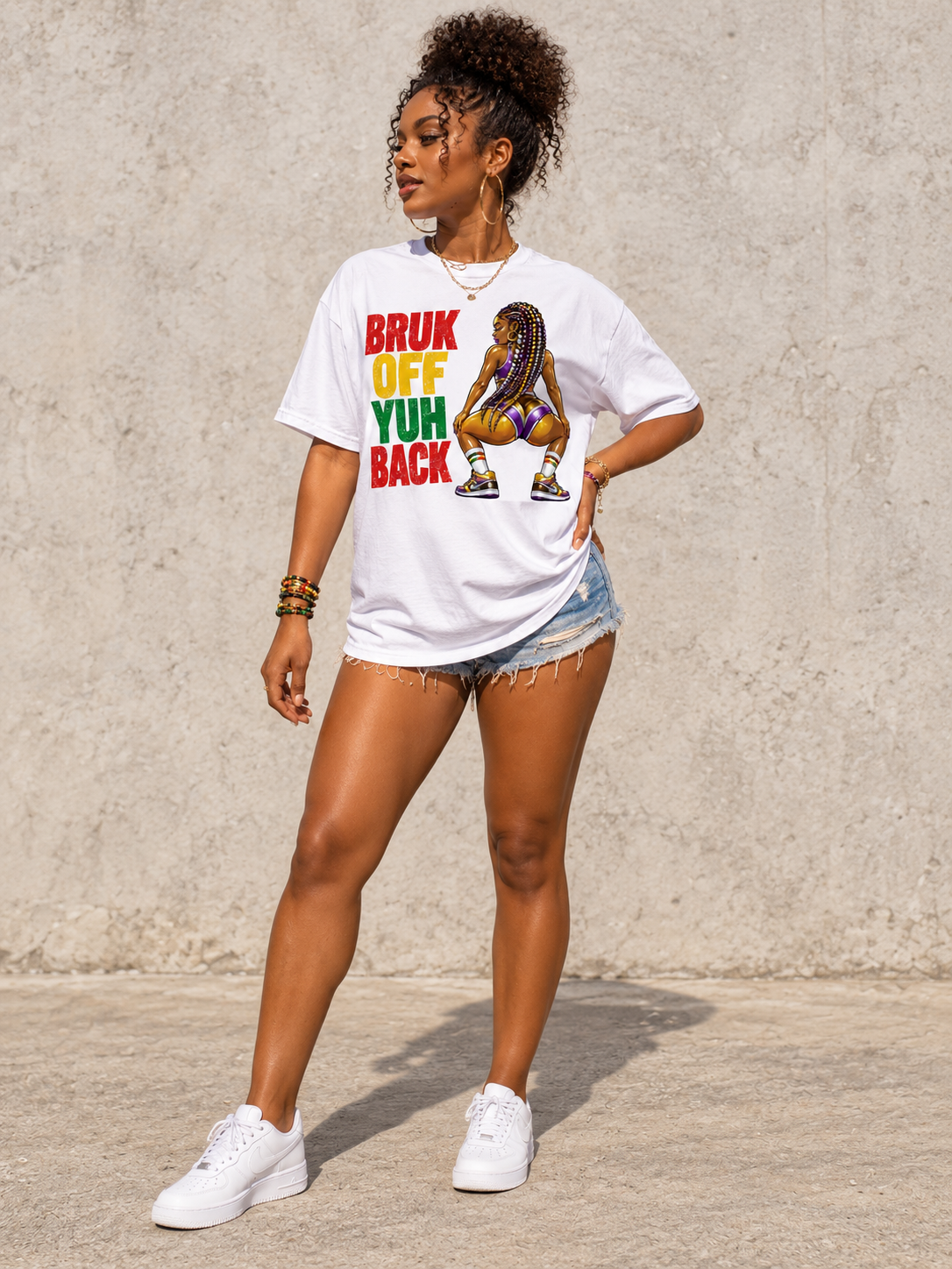 Model wearing Bruk Off Yuh Back Carnival Tee, front view showing the design, against a light concrete backdrop.