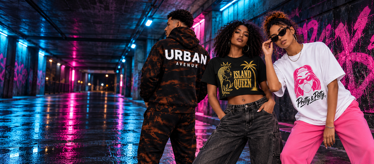 Three models wearing an Urban Avenue bleach-wash tracksuit and Moda Originals Island Queen and Pretty & Petty tees in a pink and blue neon-lit urban underpass.