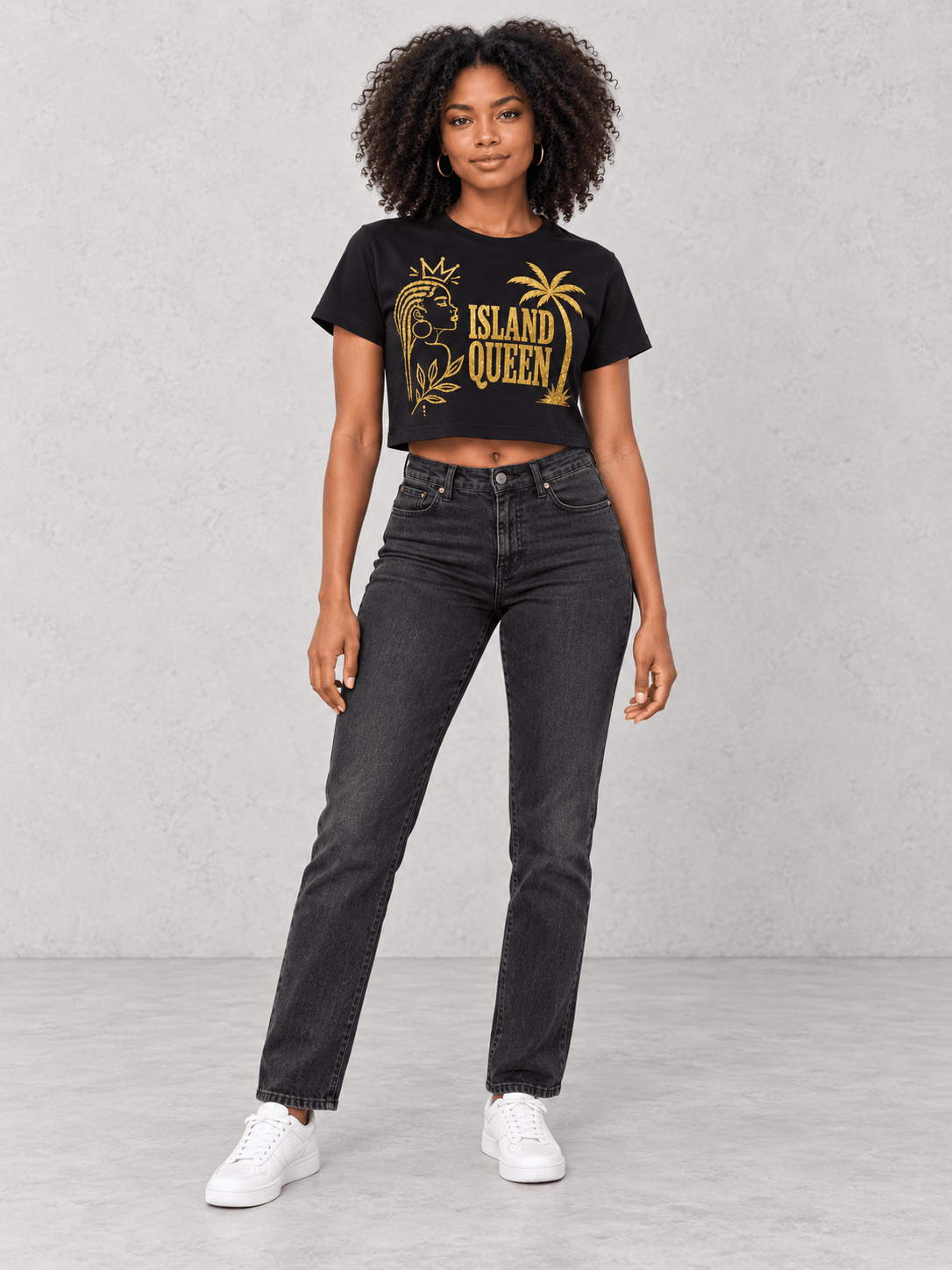 Model wearing Moda Originals Island Queen Crop Tee — Black, front view showing the design, against a light concrete backdrop.
