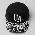 Urban Avenue UA baseball cap in black and white, top view.