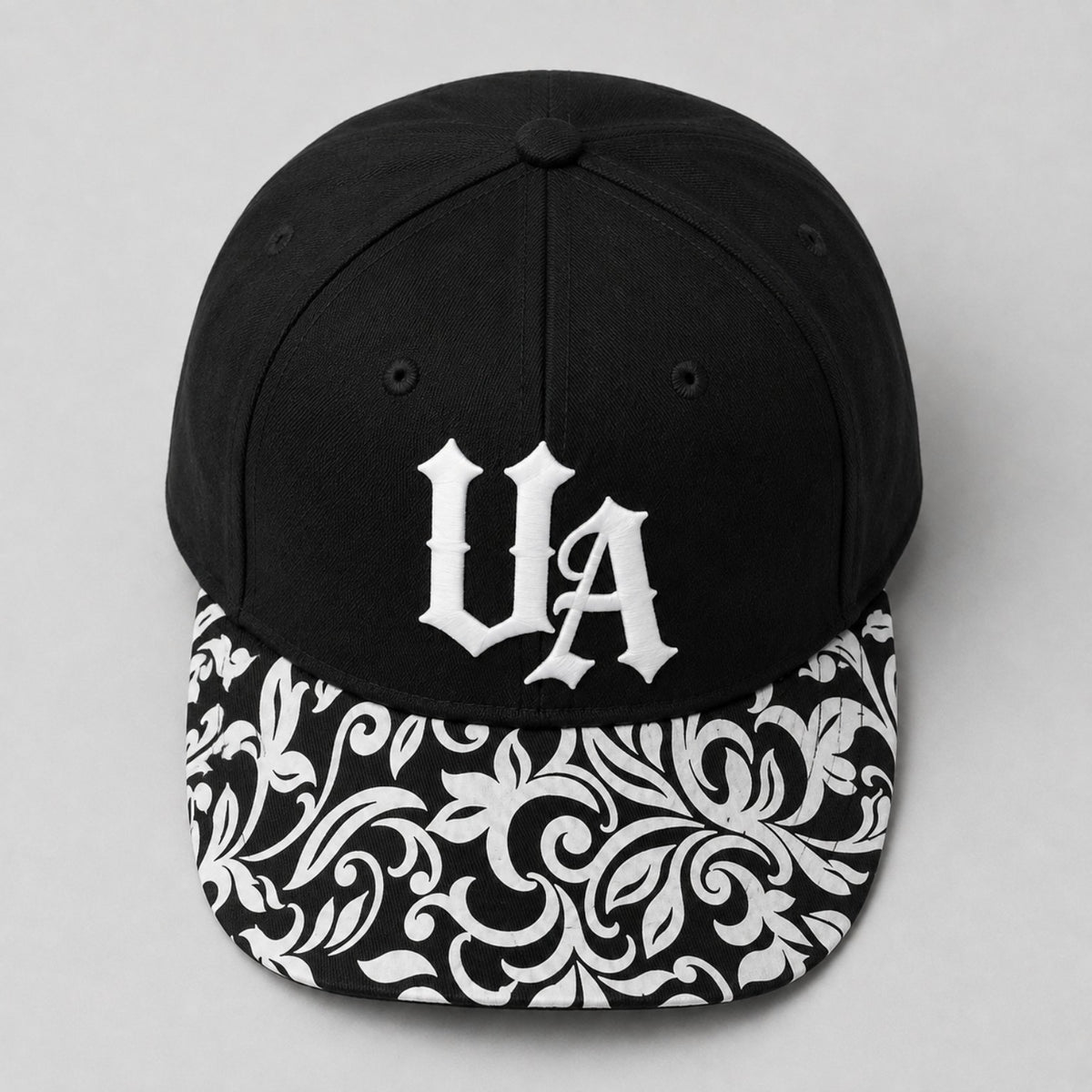 Urban Avenue UA baseball cap in black and white, top view.