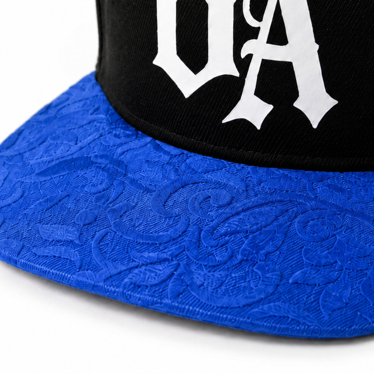 Close-up of blue patterned peak and white UA logo on Urban Avenue snapback.