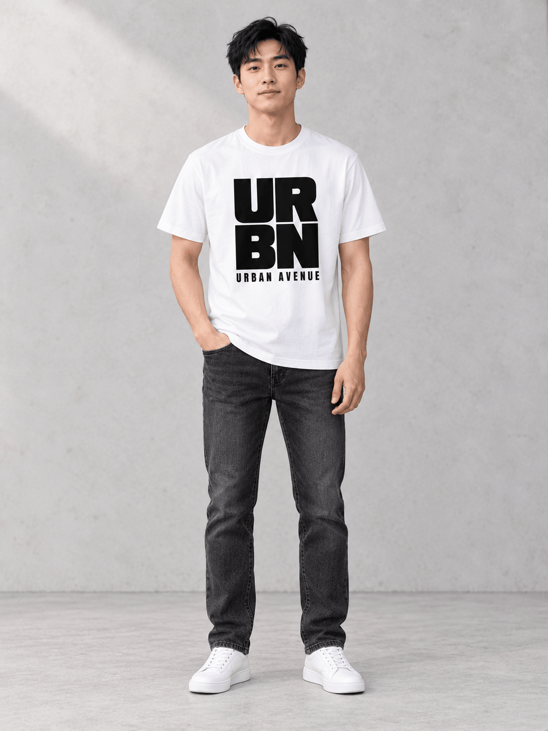 Model wearing Urban Avenue URBN Tee, front view showing the design, against a light concrete backdrop.